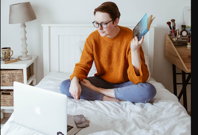 Student sitting on Bed staring at screen