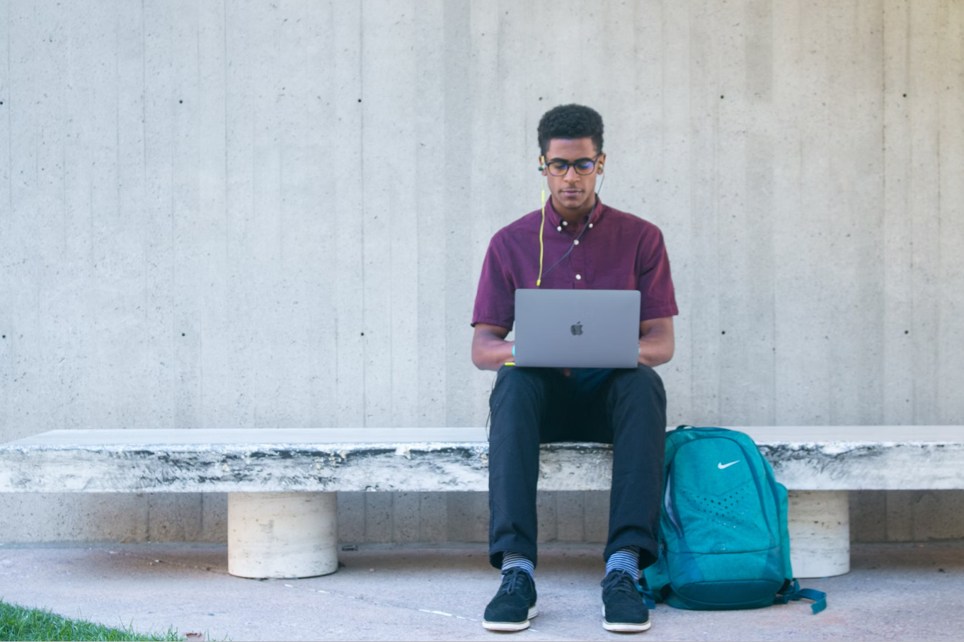 Student Sitting on a Stone Bench Working