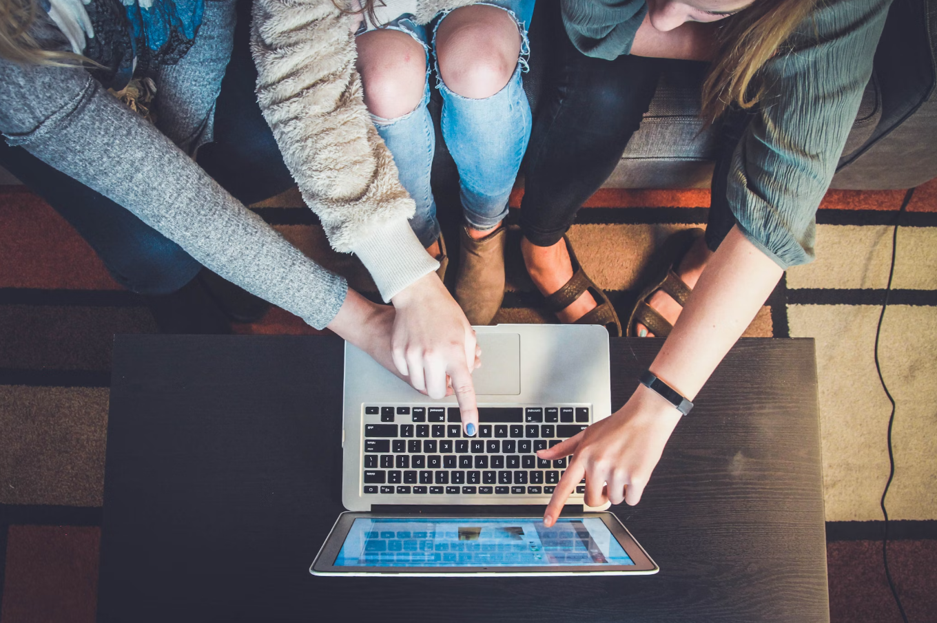 Several Students Collaborating around a laptop