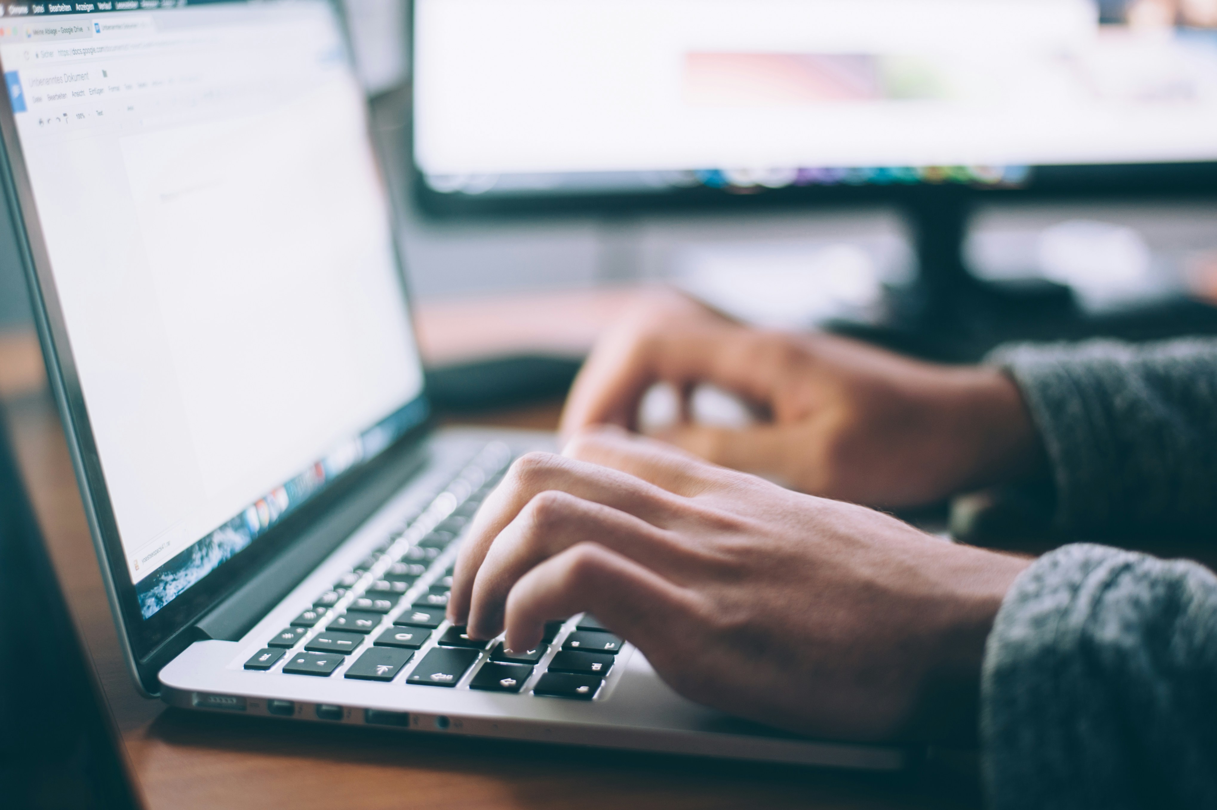 A person typing on laptop in dark