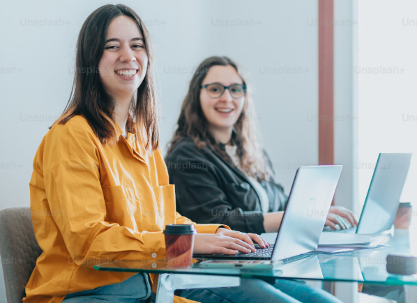 Two students smiling happily while working
