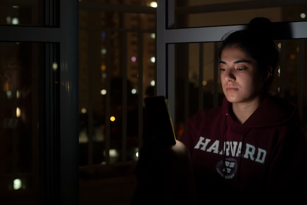 Student wearing Harvard shirt working hard